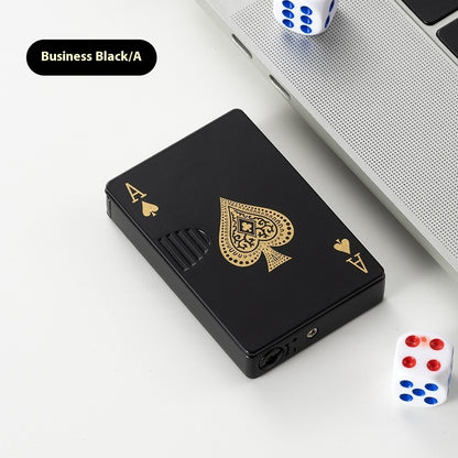 Black poker card-shaped zinc alloy lighter with gold ace of spades design on white surface near dice and laptop