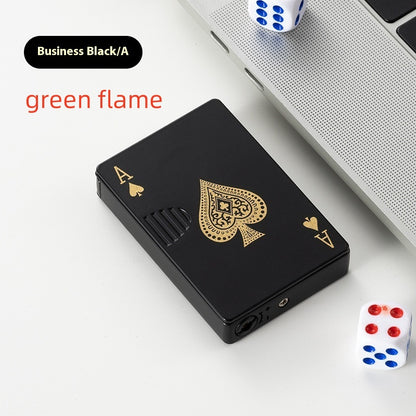 black zinc alloy lighter with golden ace of spades poker card design on white desk near laptop and dice