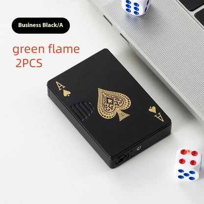 black ace spade poker card zinc alloy lighter with gold design next to dice and laptop