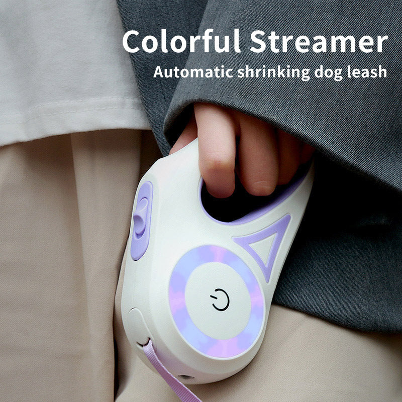 Hand holding white and purple automatic retractable dog leash with ergonomic handle and LED ring