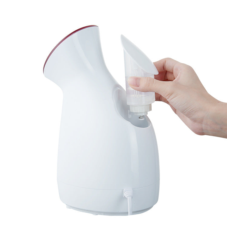 Hand inserting water container into white facial steamer with hot spray and nano ion technology