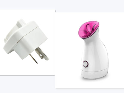 White facial steamer with purple nozzle and round power button, and a white European plug adapter
