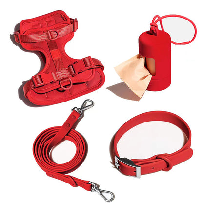 Red dog harness, leash, collar, and poop bag dispenser on white background