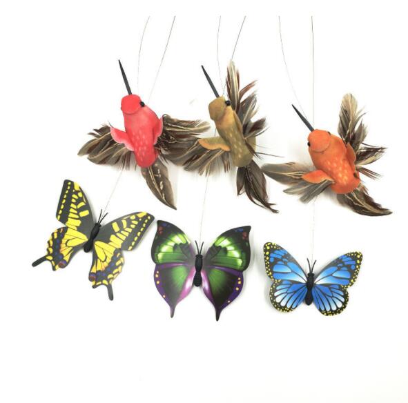 Three colorful bird toys with feather wings and three vibrant butterfly toys hanging against white background