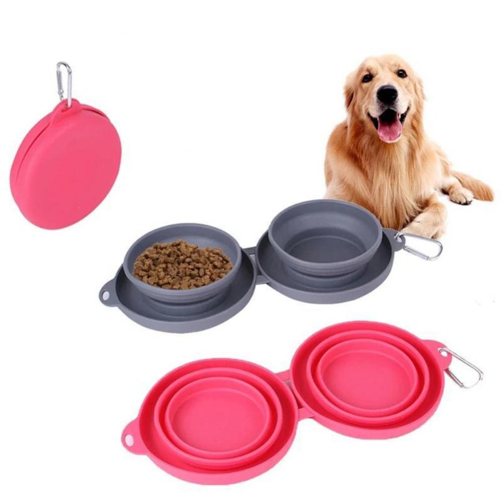 Collapsible double pet bowls in pink and gray with dog food, featuring carabiner clips and a happy golden retriever