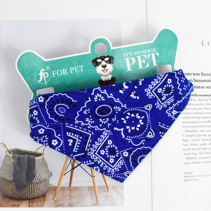 Blue paisley patterned pet bandana on green packaging with dog illustration, durable polyester design