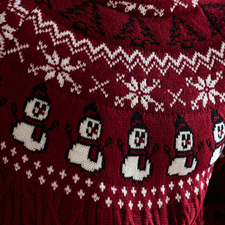 Close-up of festive red Christmas sweater with white snowflakes and snowman pattern cable knit