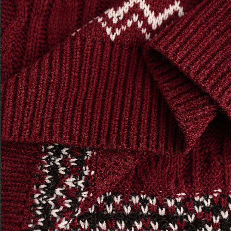 Close-up of festive red cable knit sweater with white and black patterned accents