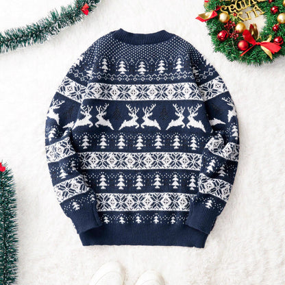 Navy blue Christmas sweater with white reindeer and tree patterns on white fuzzy background