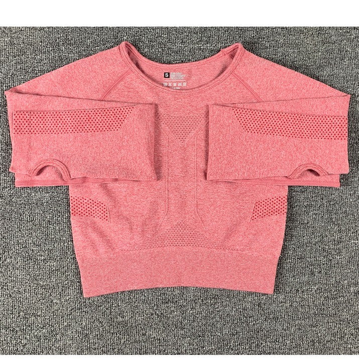 Red women's seamless cropped workout top with mesh ventilation on sleeves and sides on gray background