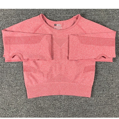 Red women's seamless cropped workout top with mesh ventilation on sleeves and sides on gray background