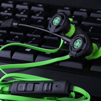 Black and green wired in-ear gaming headset with microphone and volume control on black keyboard