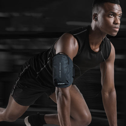 Athlete wearing black reflective running arm bag on upper arm in starting pose with earphones