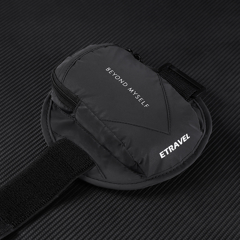Black reflective running arm bag with zipper, text Beyond Myself and ETRAVEL on textured dark background