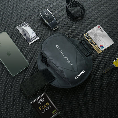 Black reflective running arm bag with Beyond Myself and Etravel logos, surrounded by car key, smartphone, cards, and cash