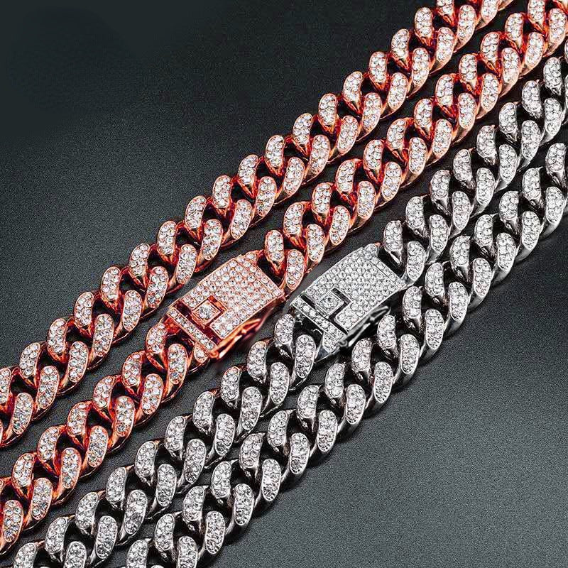 Two hip hop dog collars with embedded rhinestones, one rose gold and one silver, on black background