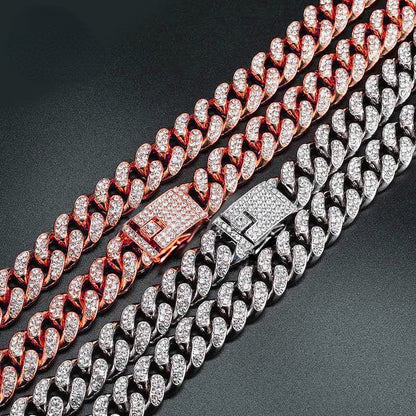 Two hip hop dog collars with embedded rhinestones, one rose gold and one silver, on black background