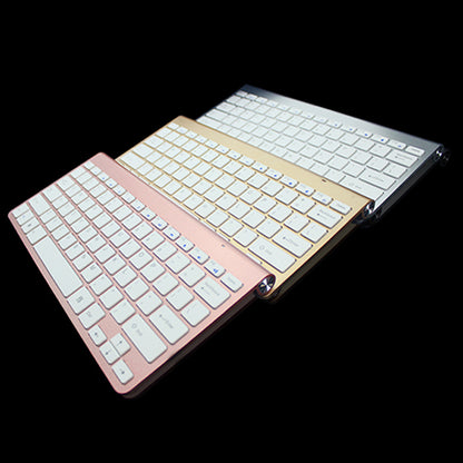Three slim wireless keyboards in rose gold, gold, and silver colors on black background