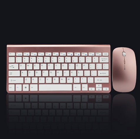 Rose gold wireless keyboard and compact mouse combo on black reflective surface