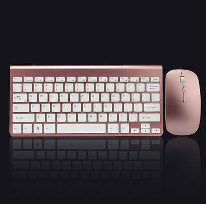 Rose gold wireless keyboard and compact mouse combo on black reflective surface