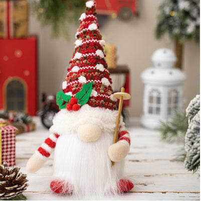 Christmas gnome decoration with red and white striped hat, white beard, and holly leaves