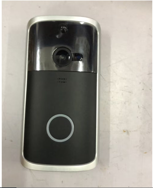 Silver and black wireless video doorbell with camera lens and circular button on white surface