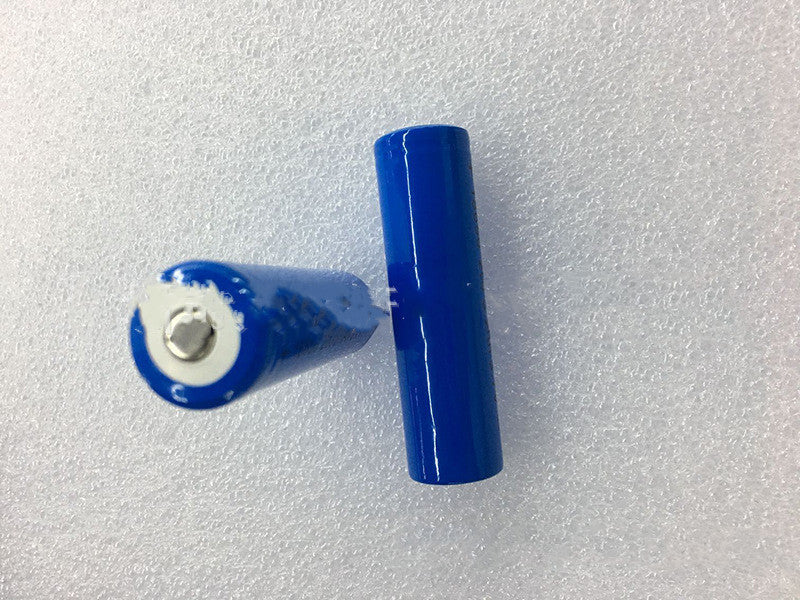 Two blue cylindrical rechargeable batteries on a white textured surface