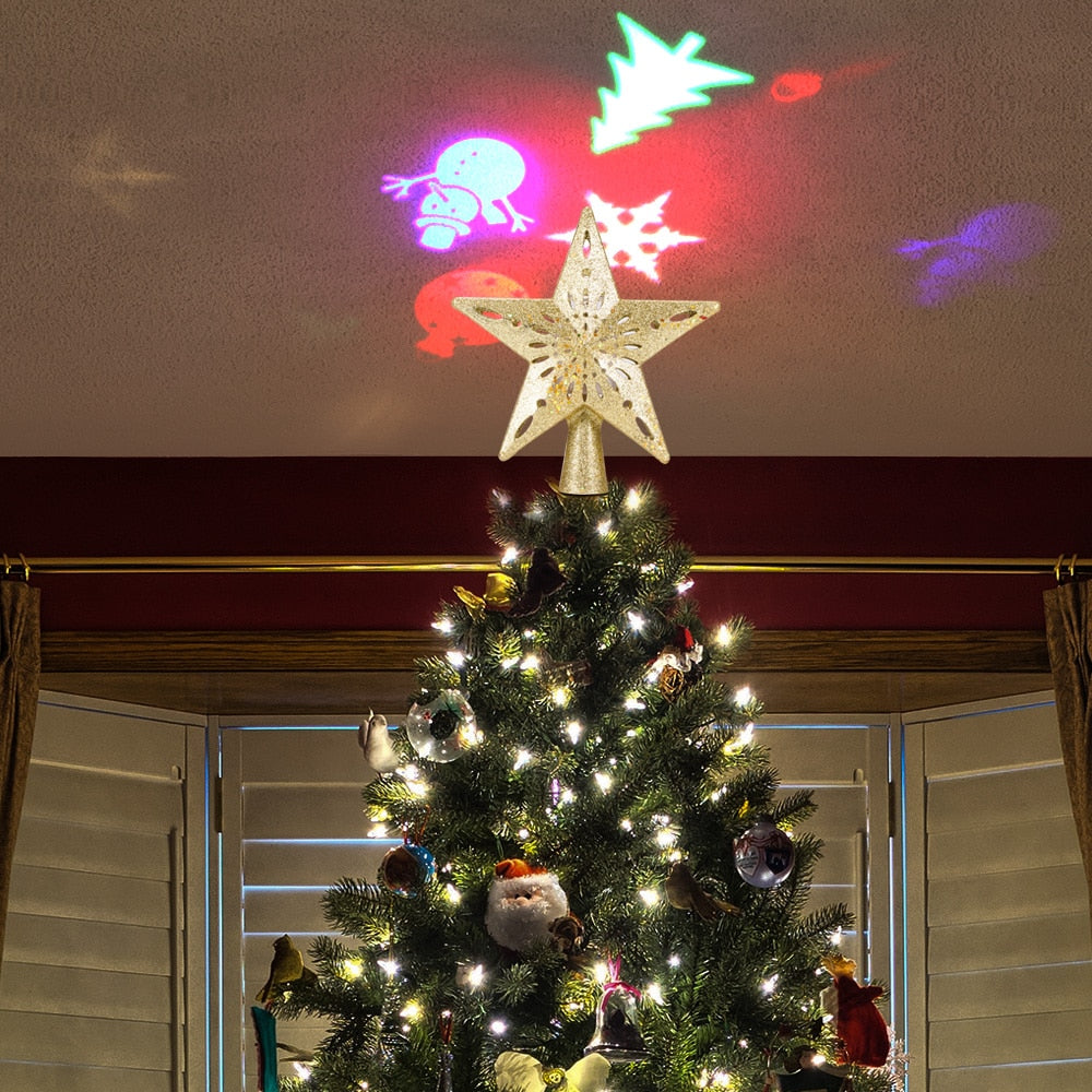 Christmas tree with star topper and white lights under colorful holiday projector snowflakes and figures on ceiling