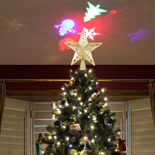 Christmas tree with star topper and white lights under colorful holiday projector snowflakes and figures on ceiling