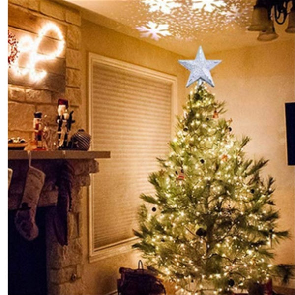 Cozy living room with illuminated Christmas tree topped by a glowing silver star and snowflake light projections