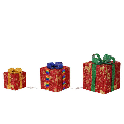 Three red glittery Christmas gift boxes with gold reindeer and snowflake patterns, decorated with yellow, blue, and green bows