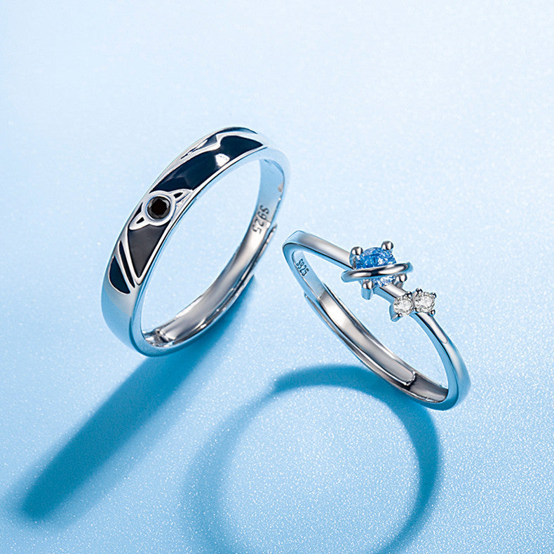 925 silver couple rings with planet design, one with black enamel and one with blue and white stones