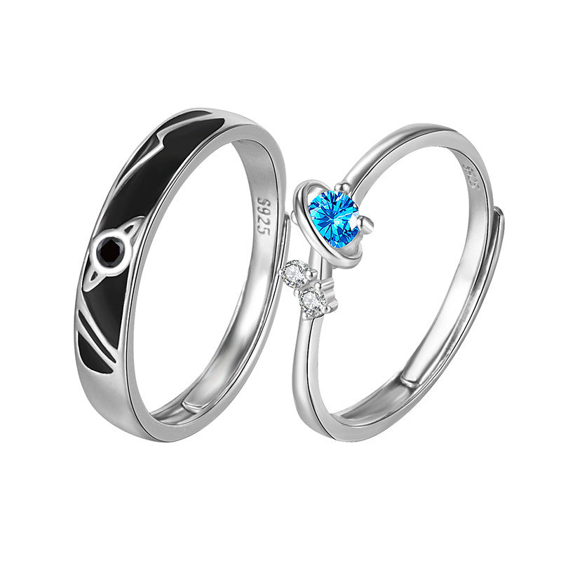 925 sterling silver couple rings, one with black planet design and one with blue and clear gemstones