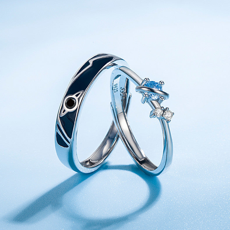 925 silver couple rings with unisex planet design and blue gemstone on light blue background