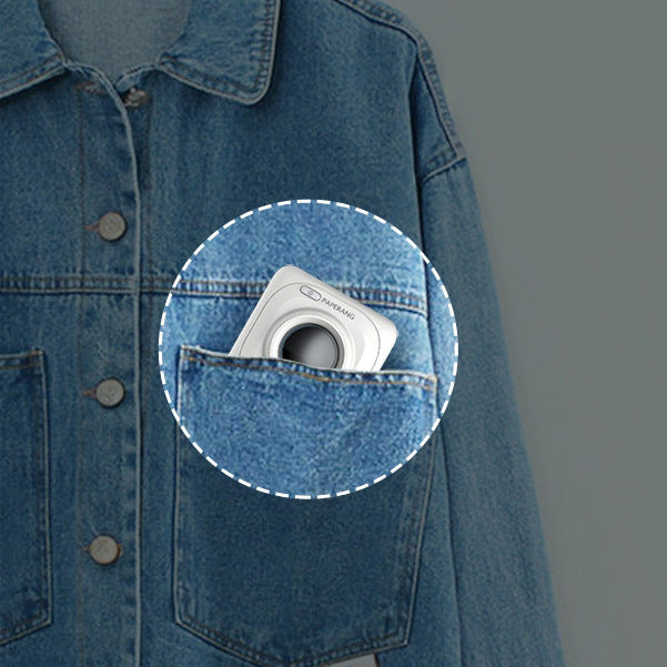 Compact white portable mini thermal photo printer in denim jacket pocket with blue background