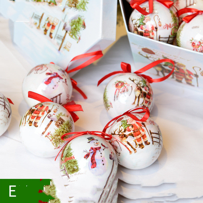 White ceramic Christmas ornaments with snowman and Santa designs, red ribbons in a festive gift box