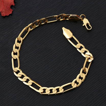 8mm silver link Figaro chain bracelet with gold copper plating on black textured surface