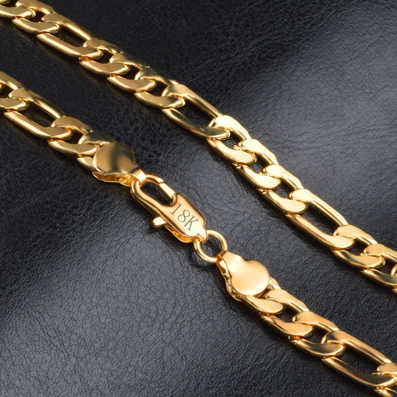 18K gold Figaro chain bracelet with polished links on black leather surface