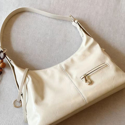 Cream-colored women's PU leather shoulder bag with front zipper pocket and adjustable strap
