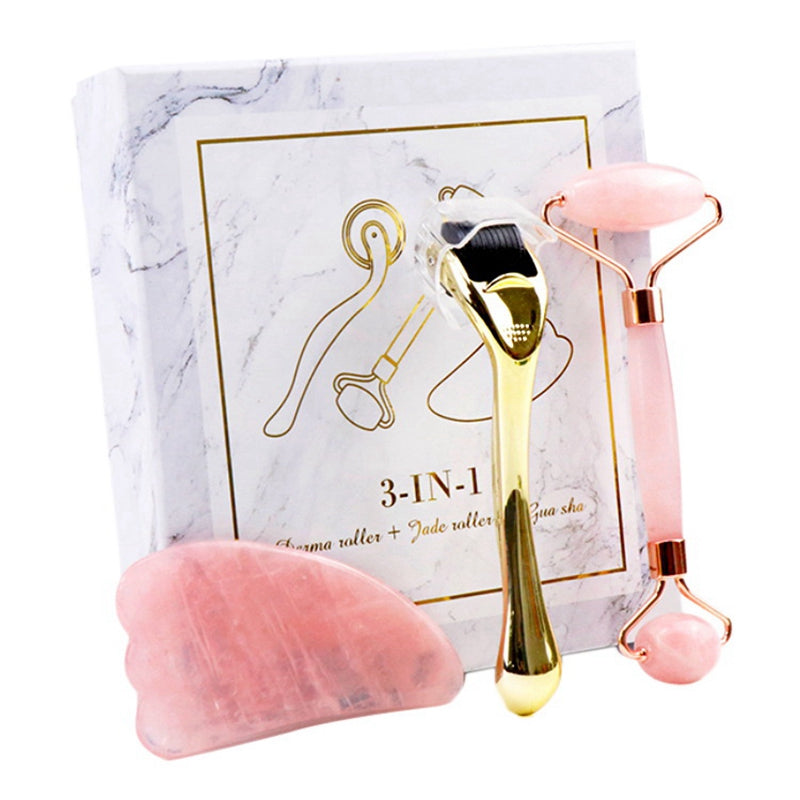 3-in-1 skincare set with gold microneedle roller, pink jade roller, and rose quartz gua sha on marble box