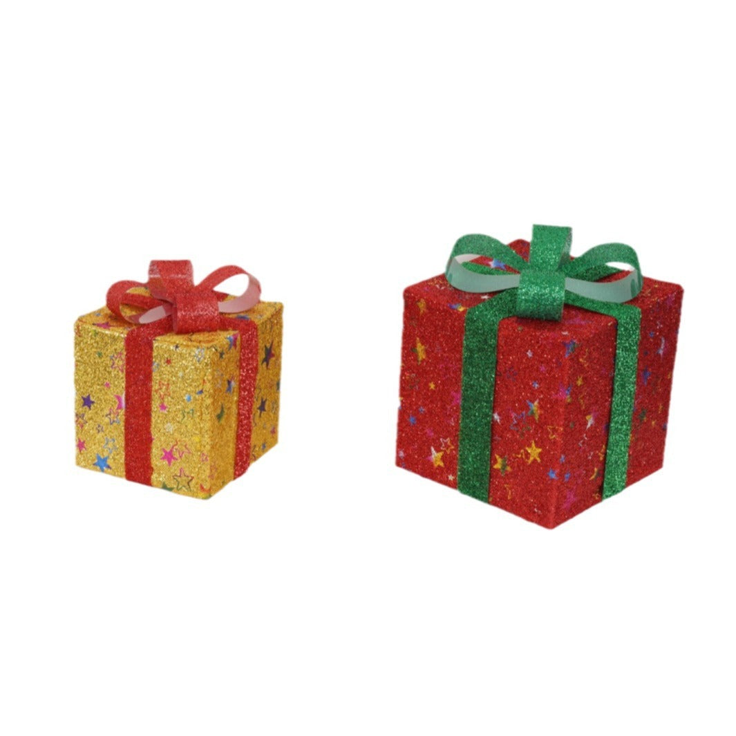Two glittery Christmas gift boxes with star patterns, one gold with red bow and one red with green bow