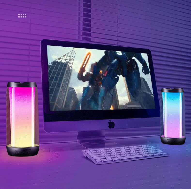 Gaming setup with iMac, wireless keyboard, and two-pack LED ambient light Bluetooth speakers with colorful glow