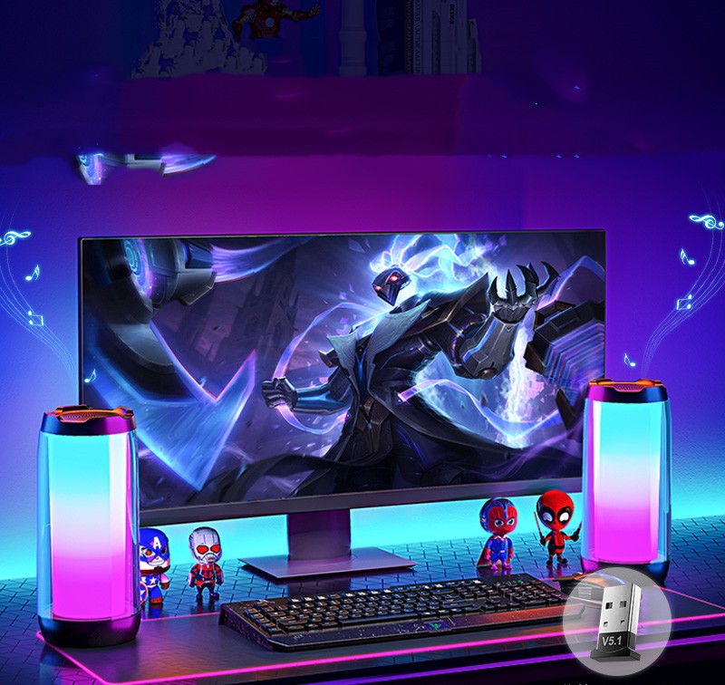 Gaming setup with RGB ambient light Bluetooth speakers, mechanical keyboard, and superhero figurines
