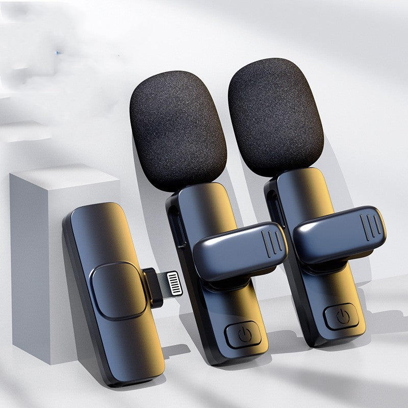 Set of two black wireless lavalier microphones with foam windshields and USB Type-C receiver on white background