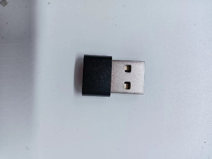 USB Type-A wireless adapter with black plastic housing on white surface