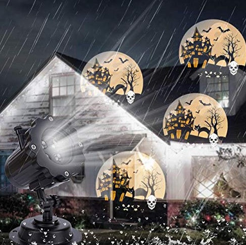 Outdoor LED laser projector displaying Halloween haunted house and skull patterns on house exterior in rainy night