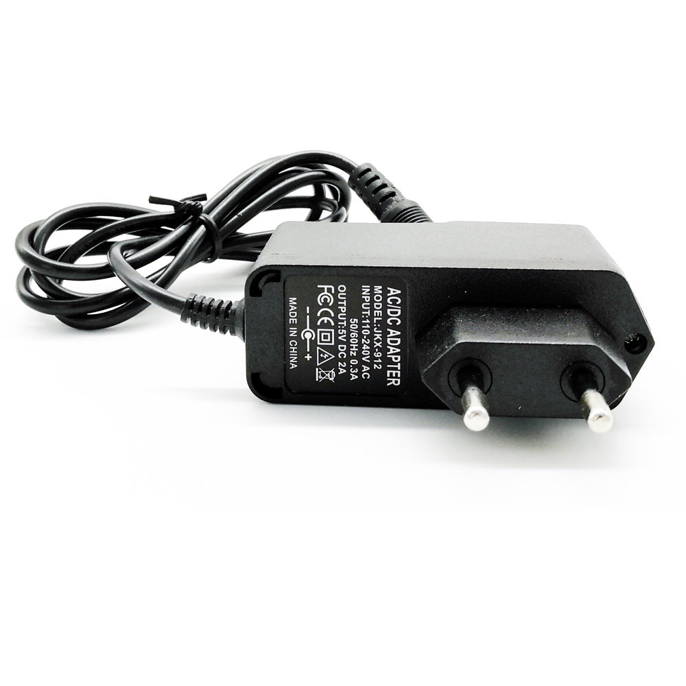 Black AC/DC adapter power supply with European plug and attached cable on white background