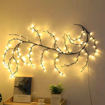 Warm white LED birch vine string lights shaped like branches on a beige wall above a desk with decorations