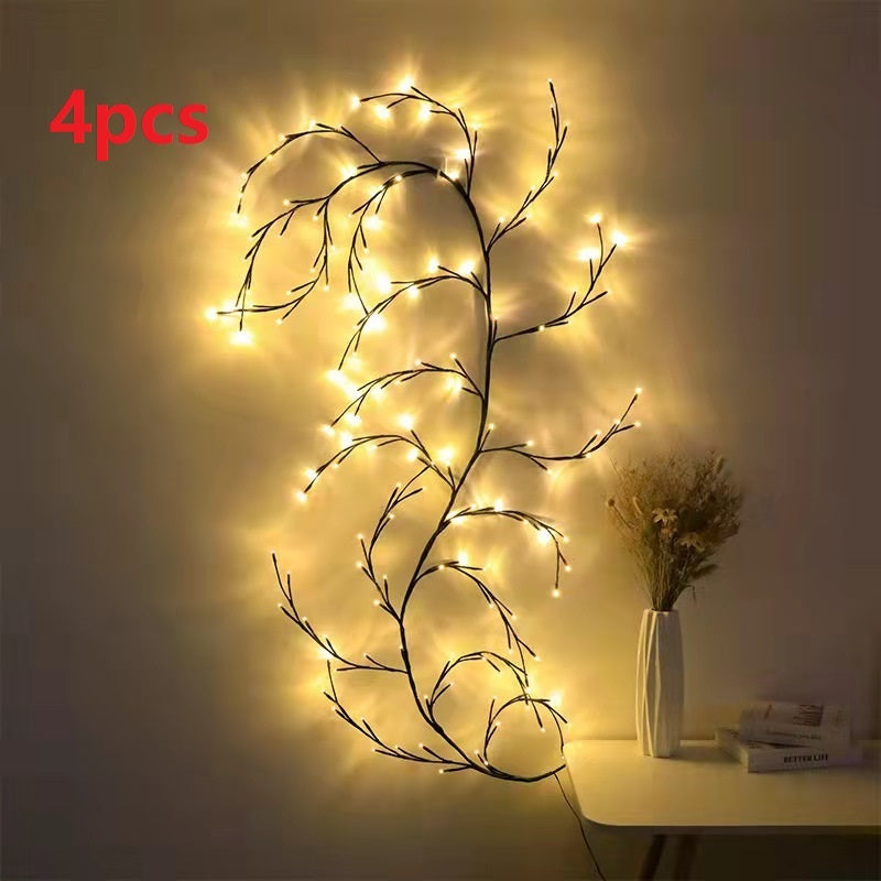 Warm white LED birch vine string lights decorating wall near vase with dried flowers on table