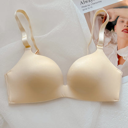 Beige wireless push-up bra with thin cups and adjustable straps on a white fabric surface